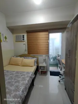a bedroom with a bed and a window and a desk at 821 Field Res Condo by Bambie with 2 wifi in Manila