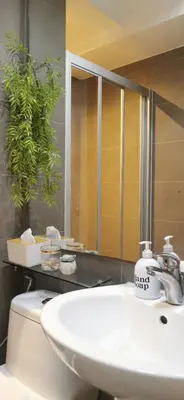 a bathroom with a sink and a toilet and a mirror at Elite Pod at Knightsbridge Residences Makati in Manila