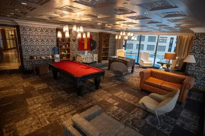 a living room with a pool table and chairs at Elite Pod at Knightsbridge Residences Makati in Manila