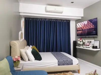 a bedroom with a bed and a blue curtain at Elite Pod at Knightsbridge Residences Makati in Manila