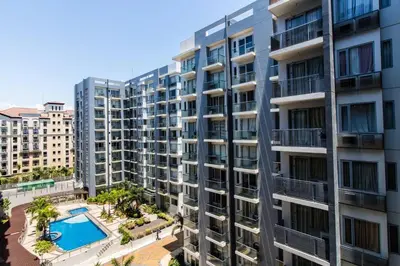an apartment building with a pool in front of it at 2 BR Condo Apartment near NAIA 3 Pasay City in Manila