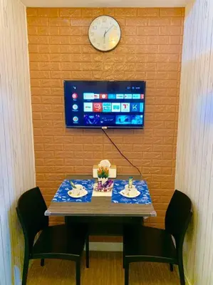a table with two chairs and a clock on a wall at Affordable Fully Furnished Condo Unit in Manila