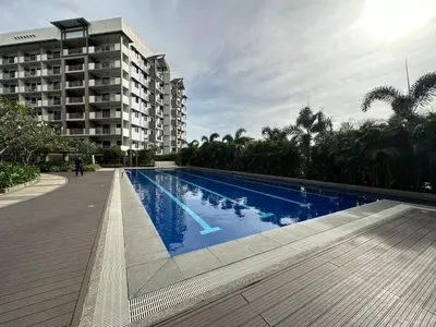 a large swimming pool in front of a building at Alea Residences in Manila