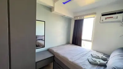 a small bedroom with a mirror and a bed at Staycation in Pasig - Near SM East Ortigas in Manila