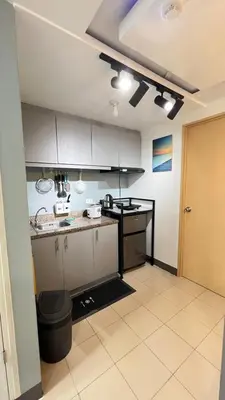 a kitchen with white cabinets and a counter top at Staycation in Pasig - Near SM East Ortigas in Manila