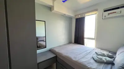 a small bedroom with a mirror and a bed at Staycation in Pasig - Near SM East Ortigas in Manila