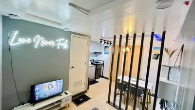 a room with a television and a room with a kitchen at Staycation in Pasig - Near SM East Ortigas in Manila