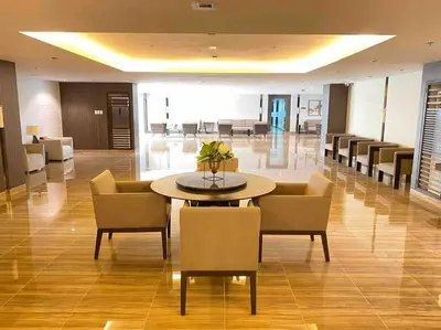 a lobby with a table and chairs in a building at Modern Classic 1 BR Condo Air Residences Makati in Manila