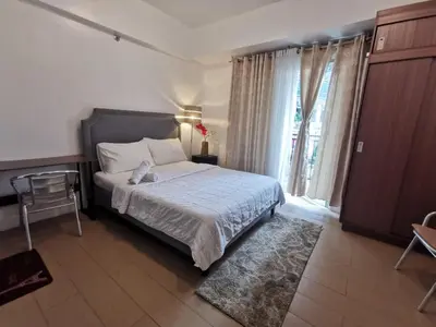 a bedroom with a bed and a large window at Staycation @150 Newport pasay city in Manila