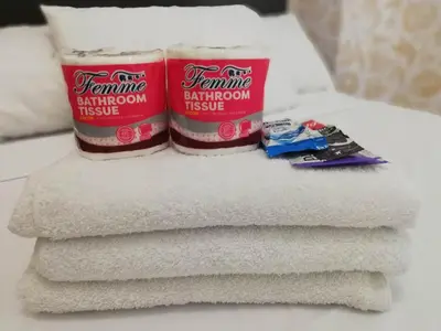 two containers of bathroom tissue sitting on top of towels at Grand riviera suites Studio Type Only in Manila