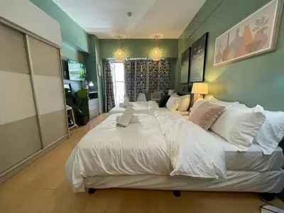 a large white bed in a large room at Poolview Family Room Greenbelt Makati in Manila
