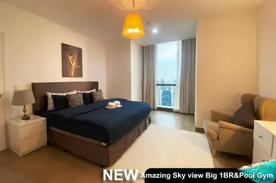 a bedroom with a bed and a couch and a window at Century Spire Makati in Manila