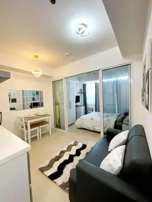 a living room with a couch and a bed at The Carribean Suites by Azure in Manila