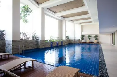 a large swimming pool with blue water in a building at Sky Staycation KL Greenbelt, Isabel's Makati Rooms in Manila