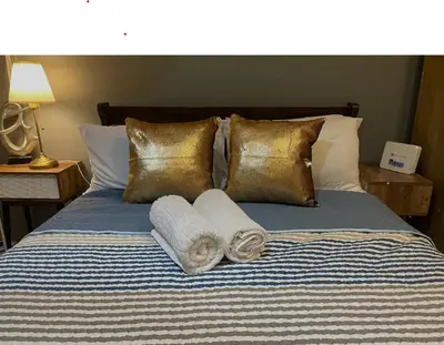 a bed with gold pillows and towels on it at Sky Staycation KL Greenbelt, Isabel's Makati Rooms in Manila