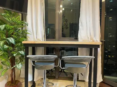 a bar with two stools in front of a window at Sky Staycation KL Greenbelt, Isabel's Makati Rooms in Manila