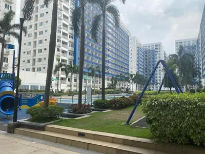 a playground in a city with palm trees and buildings at Sea Residences Tower F in Manila