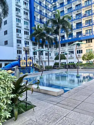 a swimming pool in front of a large building at Sea Residences Tower F in Manila