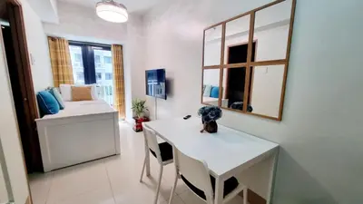a white room with a table and a mirror at Shore 3 Residences Mall of Asia Pool view Netflix free wifi in Manila