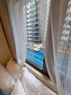 a bedroom with a bed and a window with a view at Shore 3 Residences Mall of Asia Pool view Netflix free wifi in Manila