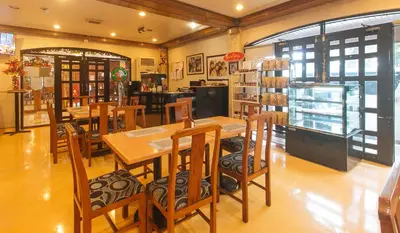 a restaurant with tables and chairs in a room at Aloha Hotel Roxas Boulevard Manila in Manila