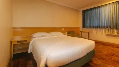 a hotel room with a bed and a window at Aloha Hotel Roxas Boulevard Manila in Manila
