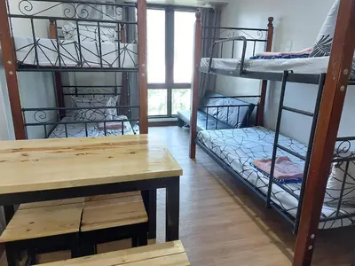 a room with bunk beds and a table and a desk at Male Room Sharing in Manila