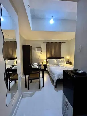 a bedroom with a bed and a table and chairs at 22-A Cozy condo in KL Mosaic Residences near Greenbelt with free WIFI in Manila