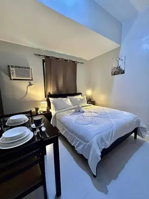 a bedroom with a bed and a table with plates on it at 22-A Cozy condo in KL Mosaic Residences near Greenbelt with free WIFI in Manila