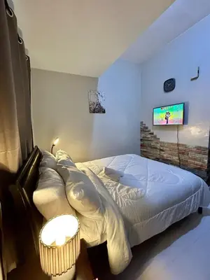 a bedroom with a bed and a tv on the wall at 22-A Cozy condo in KL Mosaic Residences near Greenbelt with free WIFI in Manila
