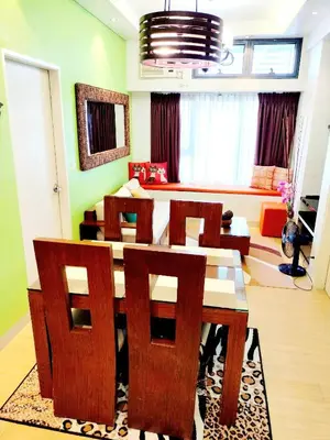 a living room with a wooden table and chairs at The Levels 2BR Condo Fully Interior Cosmo Living in Manila