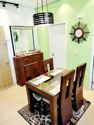 a dining room table with chairs and a clock on the wall at The Levels 2BR Condo Fully Interior Cosmo Living in Manila