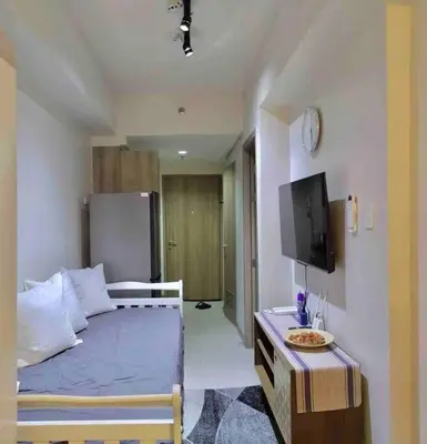 a bedroom with a bed and a tv in a room at MoA S Residences Family Suite with balcony in Manila