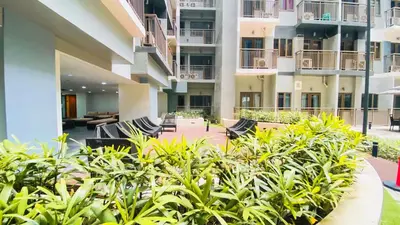 an apartment patio with chairs and plants at MoA S Residences Family Suite with balcony in Manila