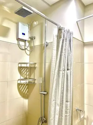 a shower with a shower curtain in a bathroom at MoA S Residences Family Suite with balcony in Manila