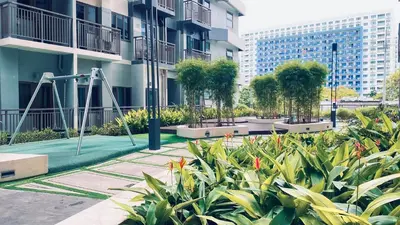 a garden with a playground in front of a building at MoA S Residences Family Suite with balcony in Manila