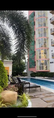 a building with a swimming pool next to a building at Lancris Residences 2 Bedroom Entire Apartment near Airport with Pool in Manila