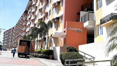a person walking down a street next to a building at Lancris Residences 2 Bedroom Entire Apartment near Airport with Pool in Manila