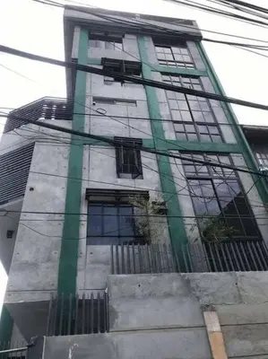 a tall building with windows on the side of it at Adorable Lounge - 1 Bedroom loft w/home cinema in Manila