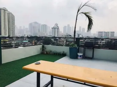 a wooden bench on a balcony with a view of a city at Adorable Lounge - 1 Bedroom loft w/home cinema in Manila