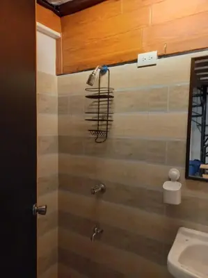 a bathroom with a shower with a hair dryer on the wall at Adorable Lounge - 1 Bedroom loft w/home cinema in Manila