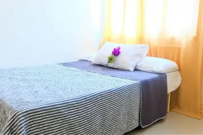 a purple flower sitting on top of a bed at StayHere SM Light by Boni MRT along EDSA in Manila
