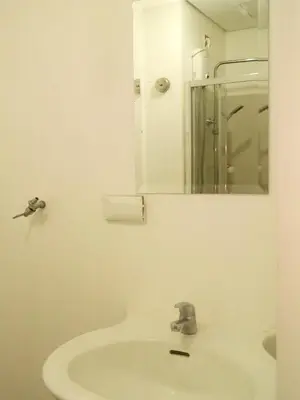 a white bathroom with a sink and a mirror at StayHere SM Light by Boni MRT along EDSA in Manila