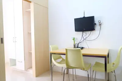 a room with a desk with chairs and a television at StayHere SM Light by Boni MRT along EDSA in Manila