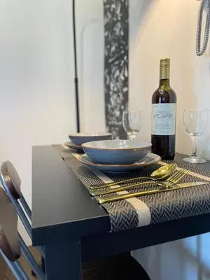 a table with a bottle of wine and glasses on it at Amazing view Makati Elegant flat 400MB internet in Manila