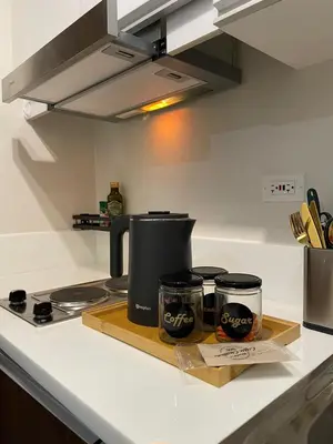 a kitchen counter with two coffee pots on a cutting board at Amazing view Makati Elegant flat 400MB internet in Manila
