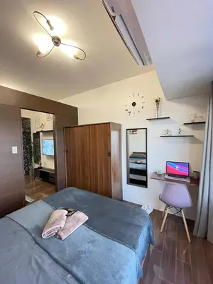 a bedroom with a bed and a desk with a laptop at Amazing view Makati Elegant flat 400MB internet in Manila
