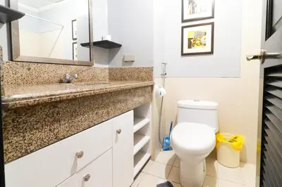 a bathroom with a toilet and a sink at StayHere - Nordic Design 2BR Serviced Apartment in Manila
