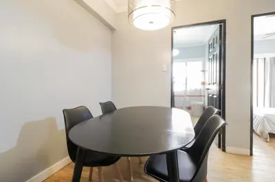 a dining room with a black table and black chairs at StayHere - Nordic Design 2BR Serviced Apartment in Manila