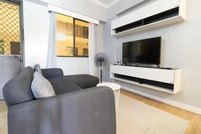 a living room with a couch and a flat screen tv at StayHere - Nordic Design 2BR Serviced Apartment in Manila